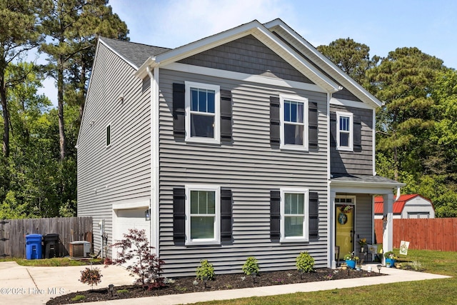 view of front of property featuring cooling unit, driveway, fence, and a garage