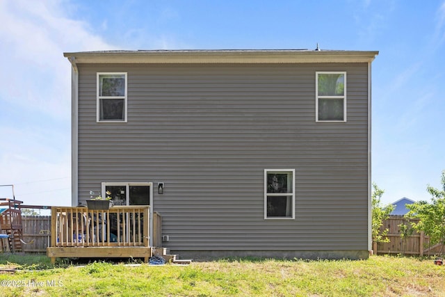 back of property with a deck and fence