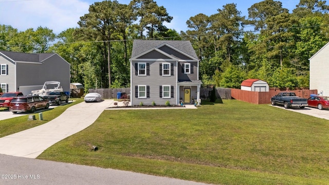 colonial inspired home featuring a storage shed, driveway, fence, and a front lawn