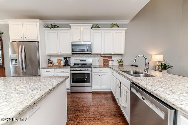 22 Calhoun Ln, Pinehurst, NC 28374 - kitchen featuring appliances with stainless steel finishes, a sink, white cabinetry, tasteful backsplash, and light stone counters