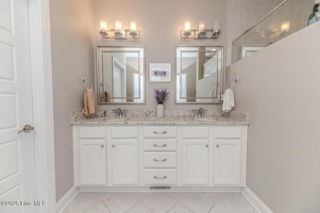 22 Calhoun Ln, Pinehurst, NC 28374 - bathroom featuring marble look tile flooring, baseboards, and double vanity