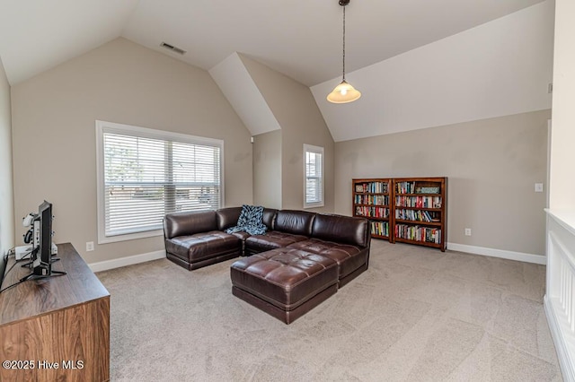 living area featuring a wealth of natural light, lofted ceiling, carpet flooring, and visible vents