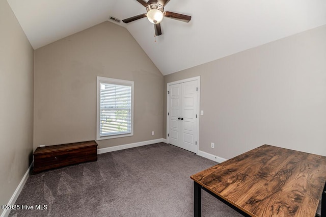 unfurnished office featuring visible vents, baseboards, dark colored carpet, a ceiling fan, and vaulted ceiling