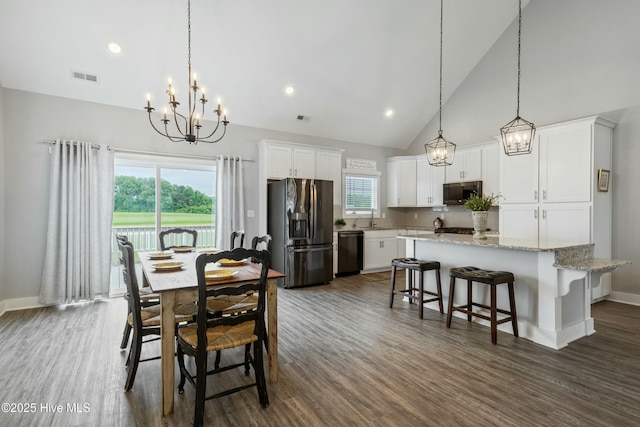 144 Pelican Pointe Dr, Elizabeth City, NC 27909 - dining space with visible vents, baseboards, an inviting chandelier, dark wood-style flooring, and high vaulted ceiling