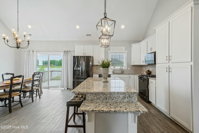 144 Pelican Pointe Dr, Elizabeth City, NC 27909 - kitchen featuring a healthy amount of sunlight, a center island, black appliances, and an inviting chandelier