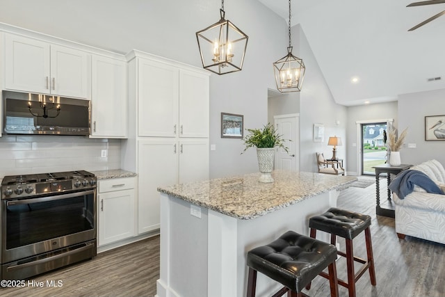 144 Pelican Pointe Dr, Elizabeth City, NC 27909 - kitchen featuring appliances with stainless steel finishes, white cabinets, backsplash, dark wood-style flooring, and high vaulted ceiling