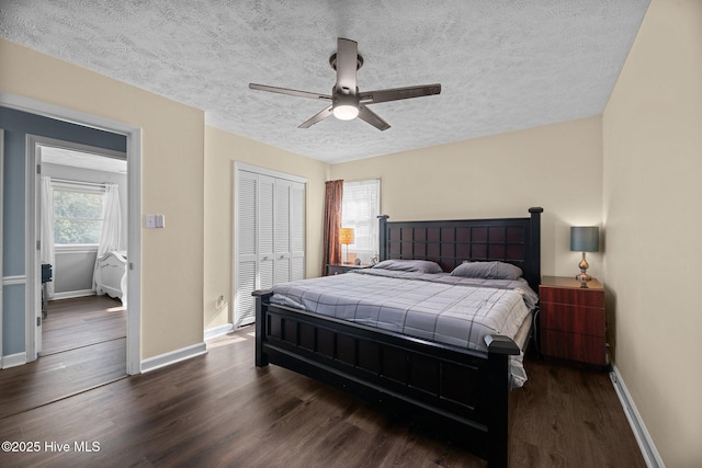bedroom featuring baseboards, a closet, a textured ceiling, and dark wood-type flooring