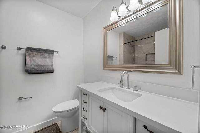 bathroom featuring toilet, baseboards, and vanity