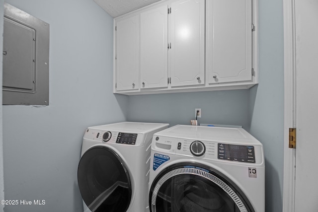 clothes washing area with independent washer and dryer, cabinet space, and electric panel