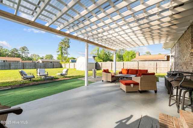 view of patio / terrace featuring a pergola, an outdoor hangout area, a storage shed, a fenced backyard, and an outdoor structure