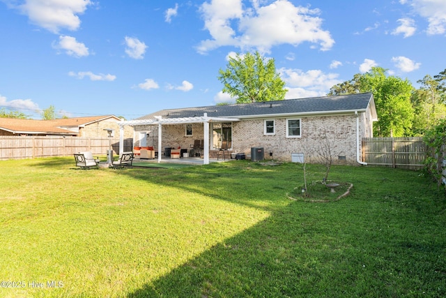 rear view of house featuring a lawn, brick siding, a fenced backyard, and a patio area