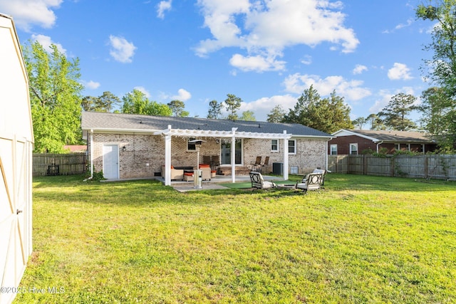 rear view of house featuring brick siding, a fenced backyard, a yard, and a pergola