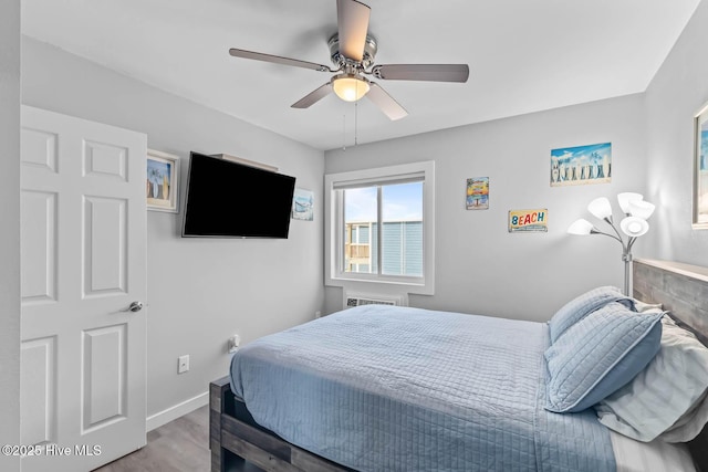 bedroom with a ceiling fan, baseboards, and wood finished floors