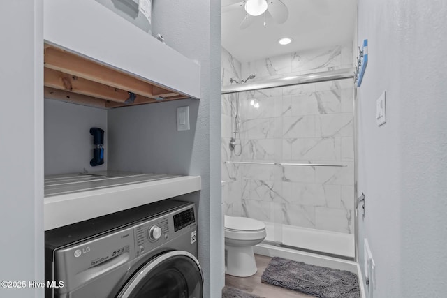 bathroom featuring washer / dryer, a marble finish shower, ceiling fan, and toilet