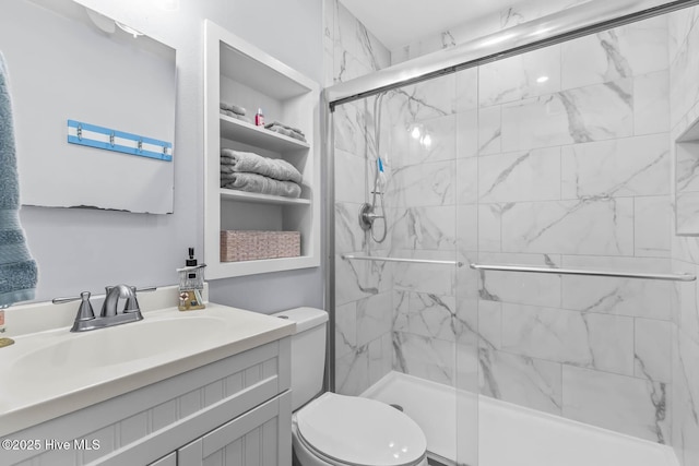 full bath featuring toilet, a marble finish shower, and vanity