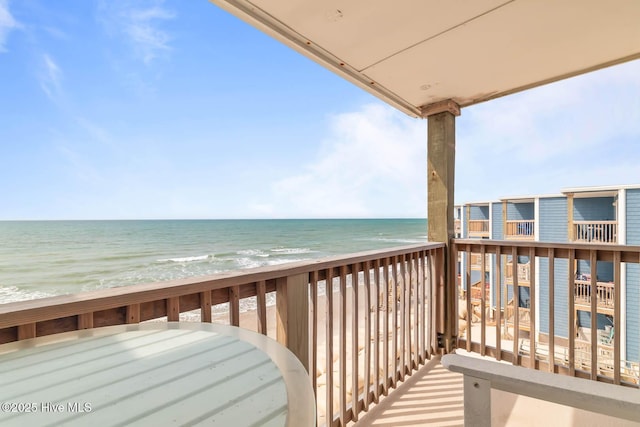 balcony featuring a beach view and a water view