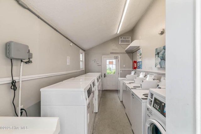common laundry area featuring a wall mounted AC and washer and dryer