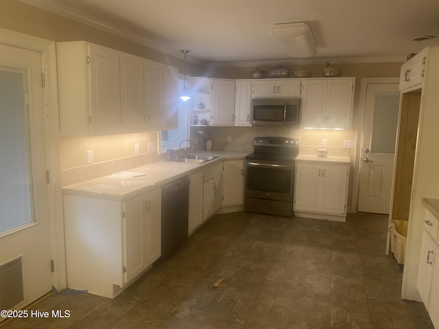 129 Cape Fear Dr, Southport, NC 28461 - kitchen with appliances with stainless steel finishes, a sink, ornamental molding, white cabinets, and light countertops