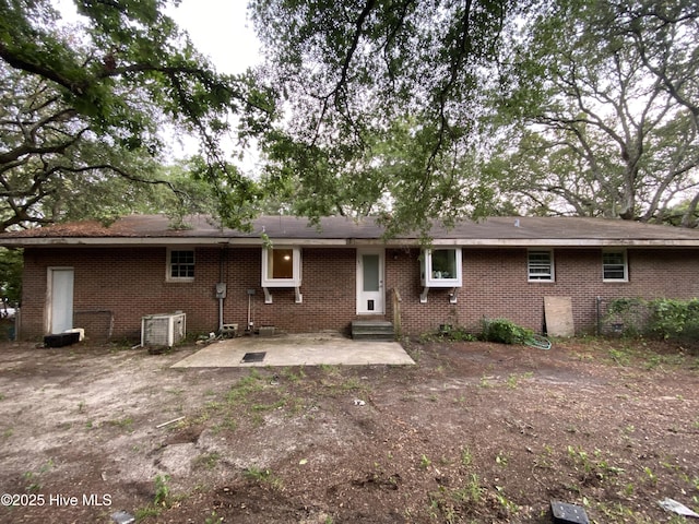 129 Cape Fear Dr, Southport, NC 28461 - back of property featuring brick siding, entry steps, a patio, and central air condition unit
