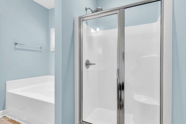 full bathroom with a shower stall and a garden tub