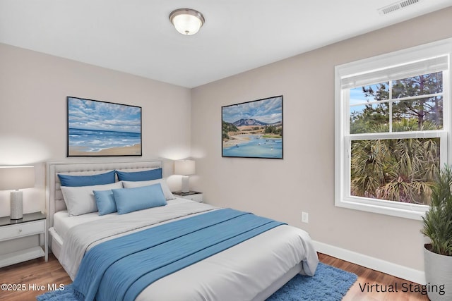 bedroom with wood finished floors and baseboards