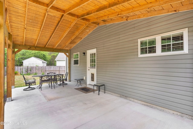 view of patio featuring outdoor dining space and fence