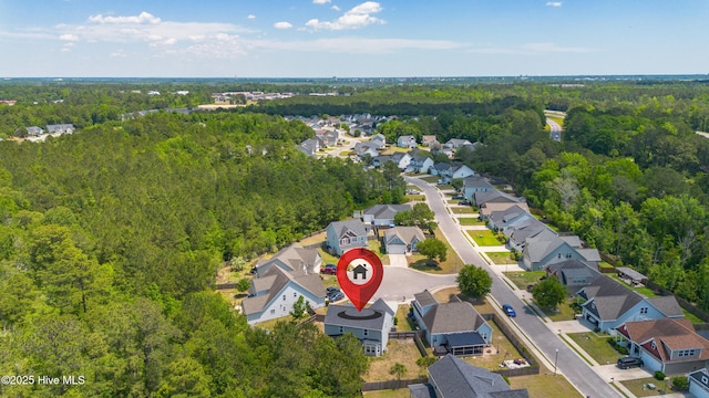 aerial view of property's location with a heavily wooded area and nearby suburban area