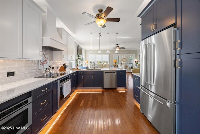 1 Gatha Ln, Ocean Isle Beach, NC 28469 - kitchen with custom range hood, a ceiling fan, dark wood finished floors, backsplash, and stainless steel appliances