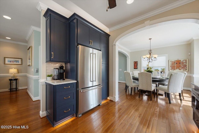 1 Gatha Ln, Ocean Isle Beach, NC 28469 - kitchen featuring light countertops, arched walkways, wood-type flooring, and high end fridge
