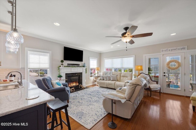 1 Gatha Ln, Ocean Isle Beach, NC 28469 - living room with a fireplace with flush hearth, a ceiling fan, dark wood finished floors, and a healthy amount of sunlight