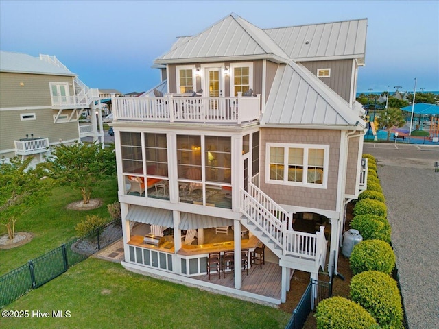 1 Gatha Ln, Ocean Isle Beach, NC 28469 - rear view of property with fence, a sunroom, a balcony, a standing seam roof, and metal roof