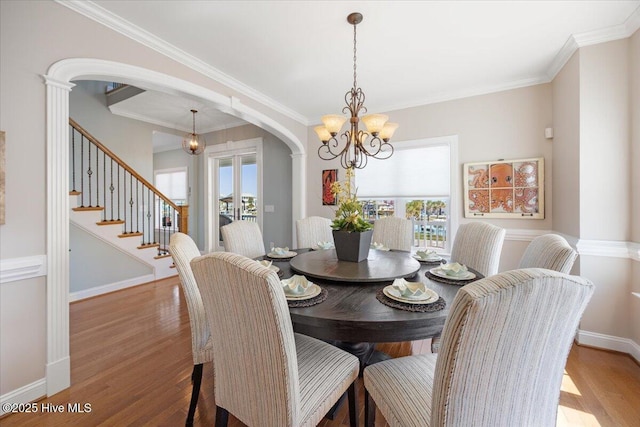 1 Gatha Ln, Ocean Isle Beach, NC 28469 - dining area featuring arched walkways, a wealth of natural light, wood finished floors, and a notable chandelier