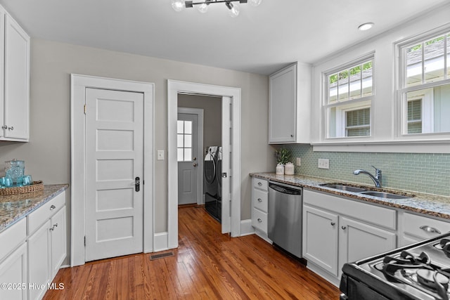 kitchen featuring black range with gas cooktop, visible vents, wood finished floors, dishwasher, and a sink