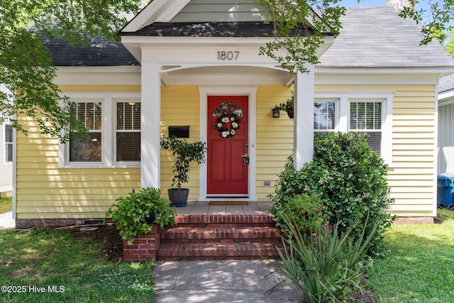 doorway to property featuring a shingled roof