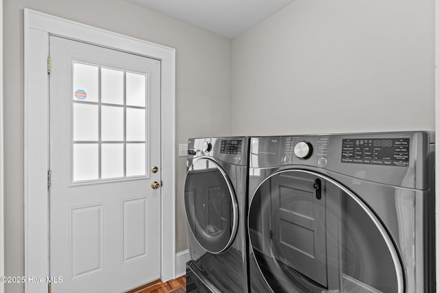 laundry area featuring baseboards, plenty of natural light, laundry area, and washing machine and dryer