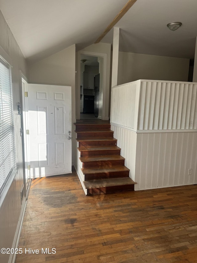 stairs featuring visible vents, vaulted ceiling, and wood finished floors
