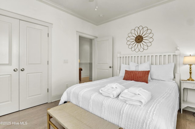 bedroom featuring crown molding, wood finished floors, and a closet