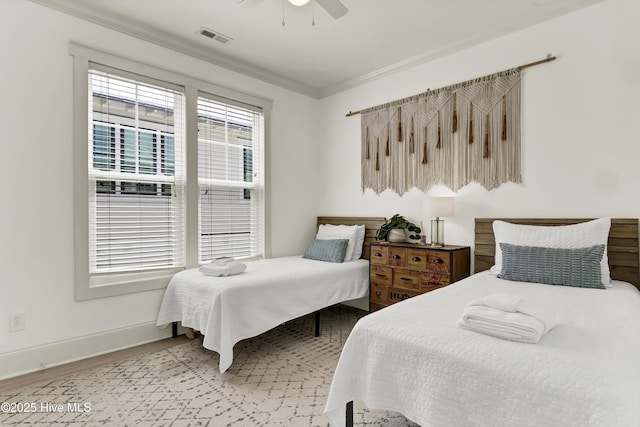 bedroom featuring visible vents, light wood-style flooring, baseboards, and ceiling fan