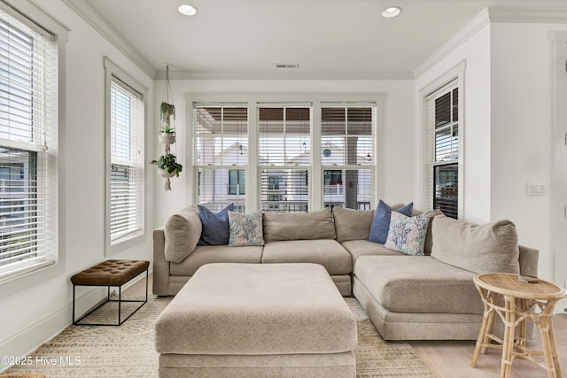 living room featuring baseboards, ornamental molding, recessed lighting, and visible vents