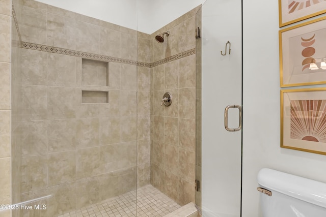 bathroom featuring a stall shower and toilet