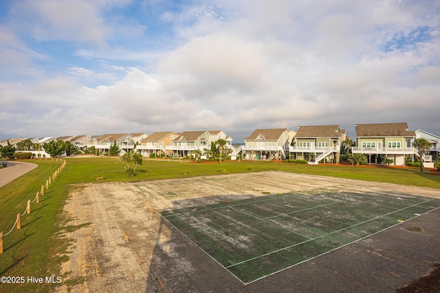 view of property's community with a lawn, uncovered parking, and a residential view