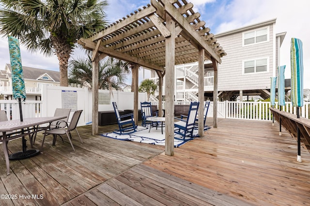 deck with outdoor dining space, a fenced backyard, and a pergola