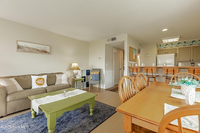 living room featuring visible vents, light wood-type flooring, and recessed lighting