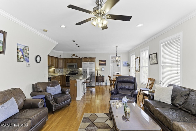 living room with light wood-style floors, recessed lighting, and ceiling fan with notable chandelier