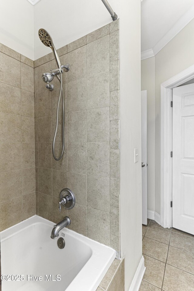 bathroom with ornamental molding, tile patterned flooring, baseboards, and tiled shower / bath