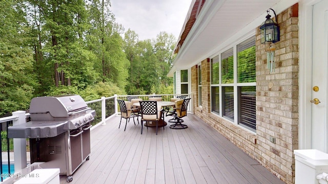 wooden deck with outdoor dining space and grilling area