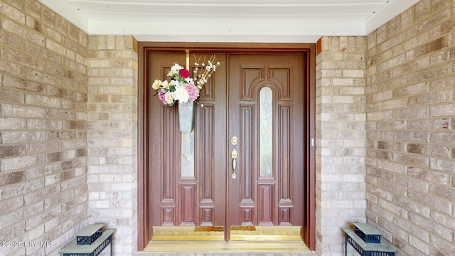 entrance to property featuring brick siding