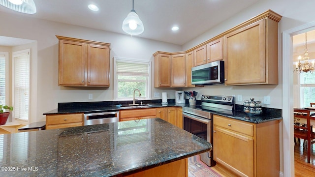 kitchen with pendant lighting, a healthy amount of sunlight, appliances with stainless steel finishes, and a sink