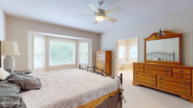 carpeted bedroom featuring a ceiling fan, a textured ceiling, and ensuite bathroom