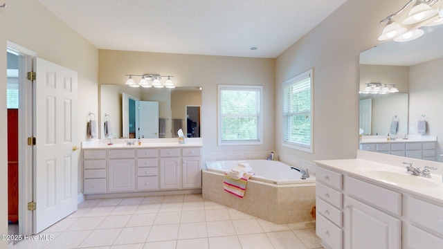 bathroom with tile patterned floors, two vanities, a bath, and a sink